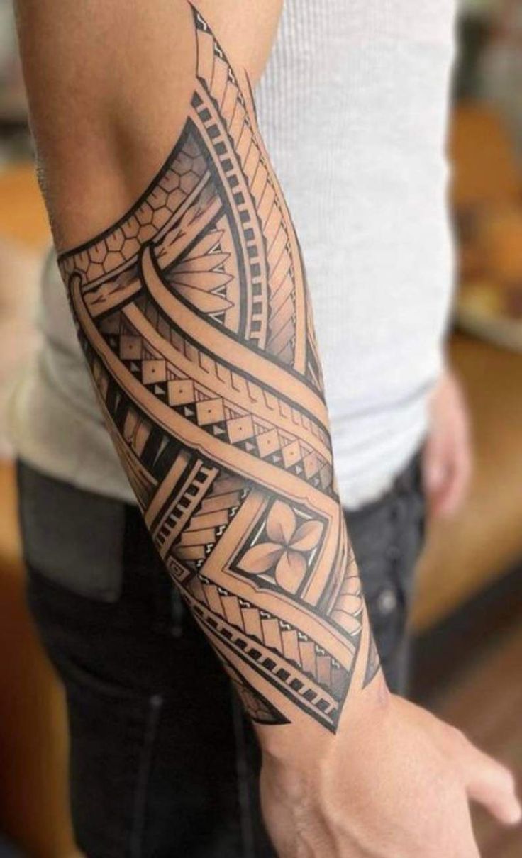 a man's arm with an intricate tattoo design on the arm and shoulder,