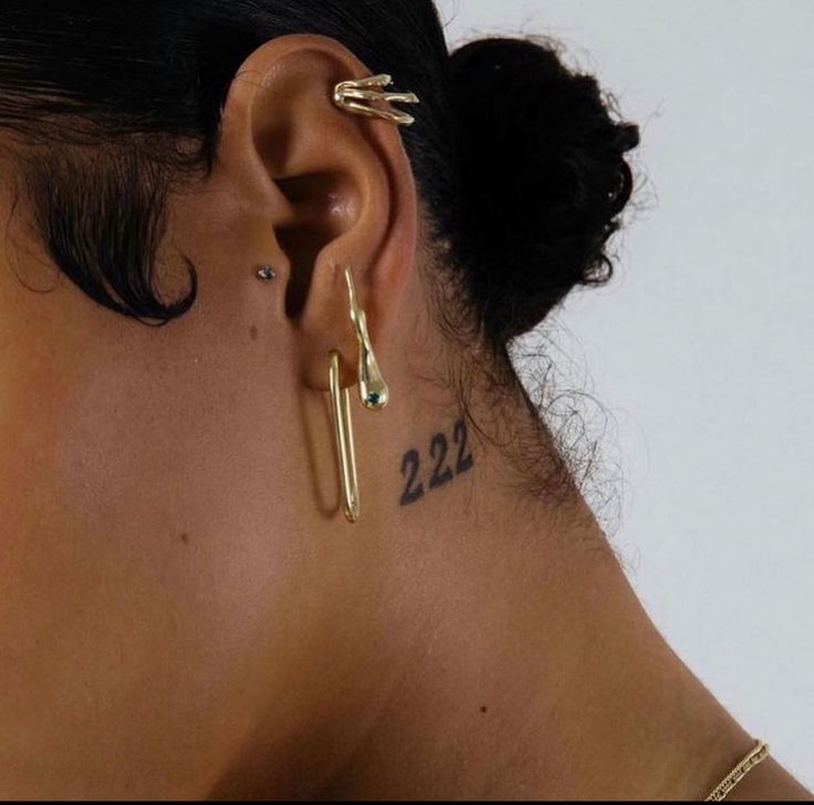 a close up of a person with ear piercings on their ears and behind her ear