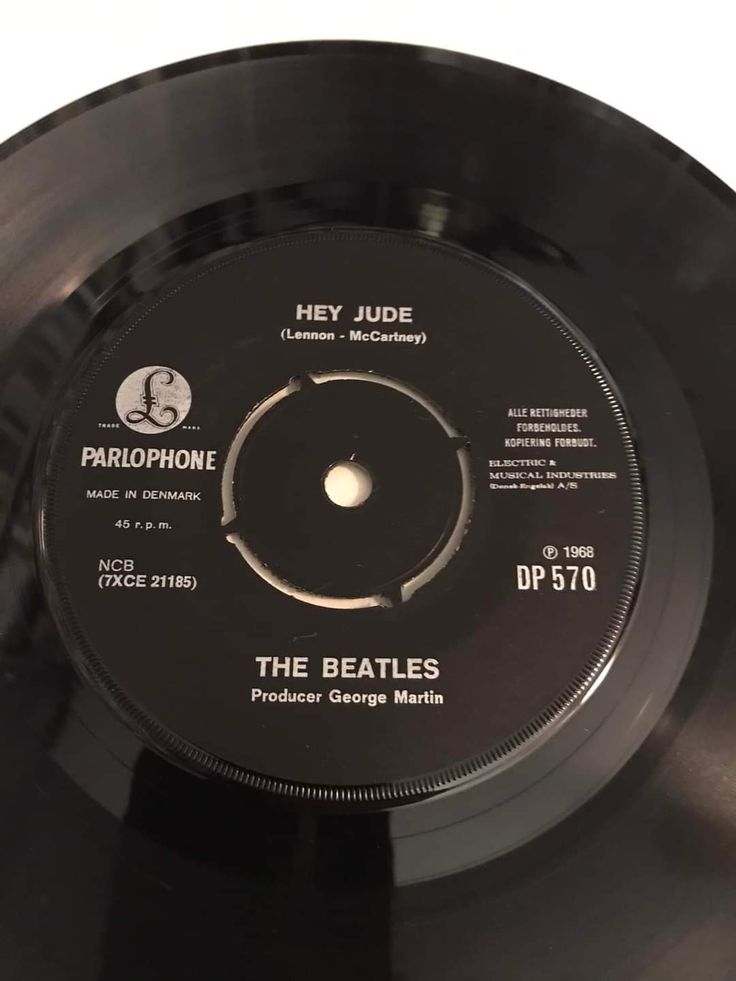 a black record with the beatles logo on it's side and an inscription that reads hey