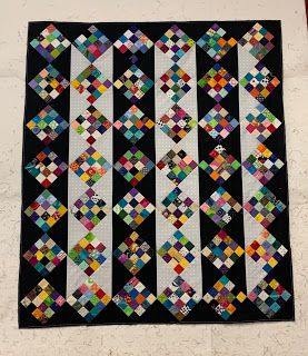 a black and white quilt hanging on the wall