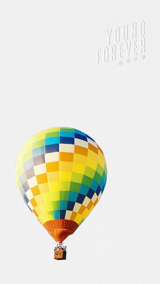 a multicolored hot air balloon flying in the sky with words young forever above it