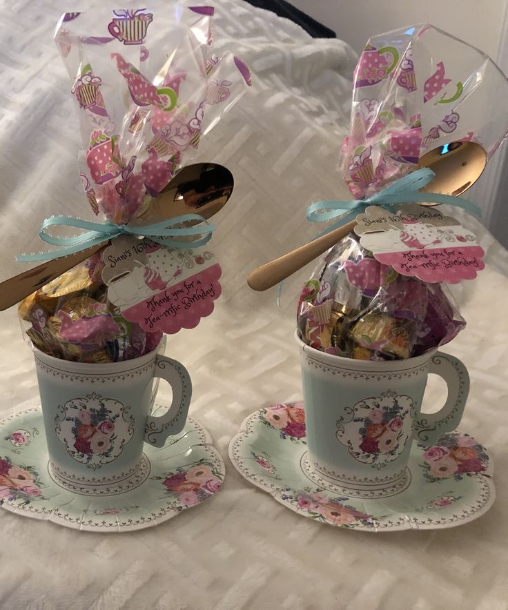 two coffee cups with spoons and candy in them