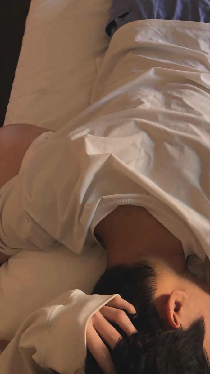 a woman laying in bed with her head on the pillow