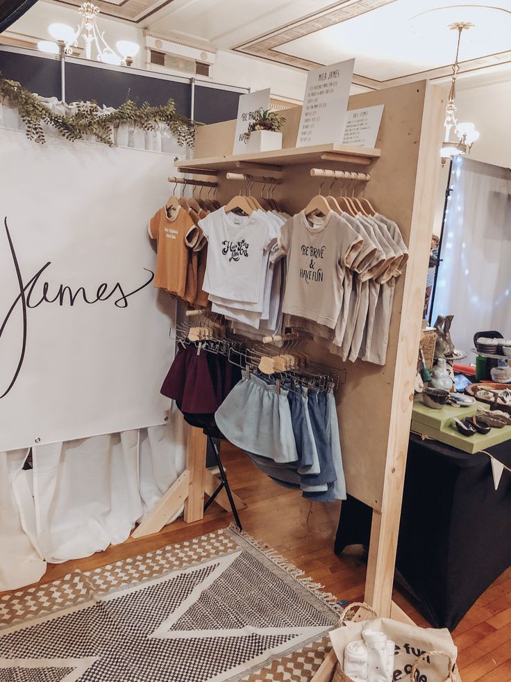 a clothing store with clothes on display and signs hanging from the wall above it that say james