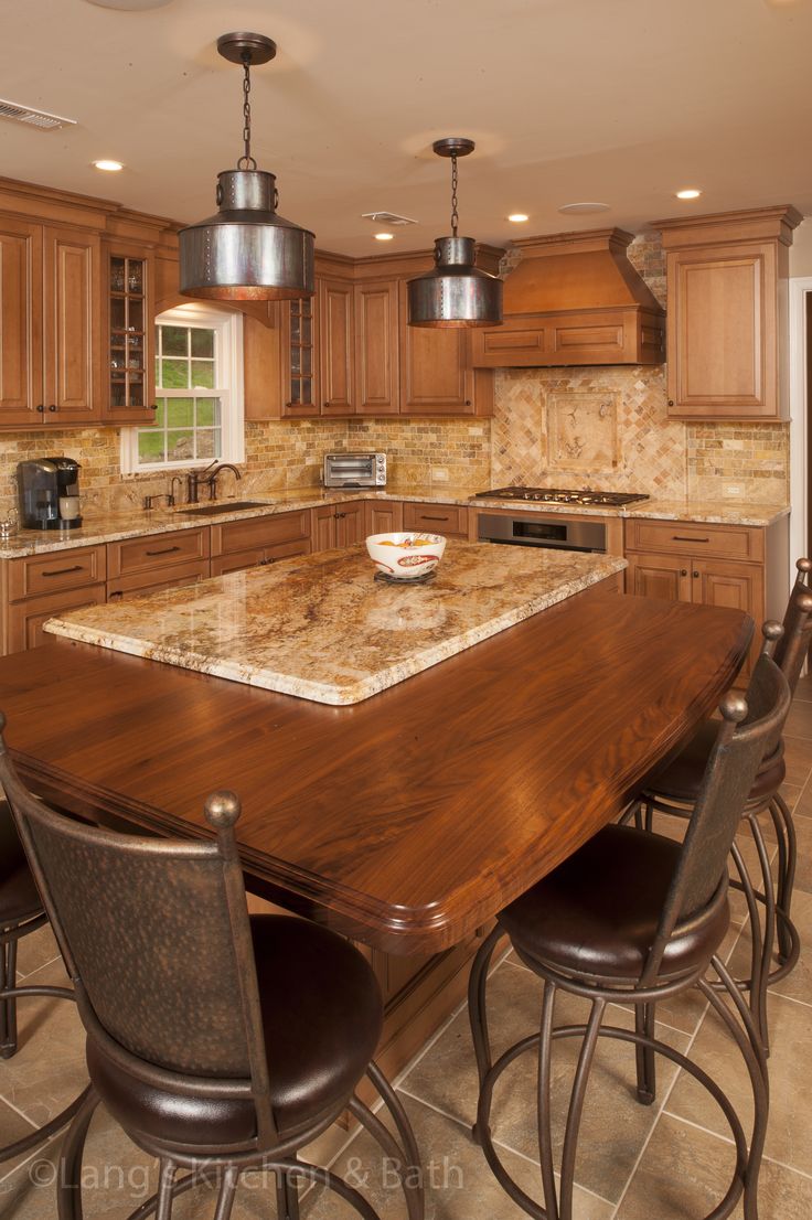 a large kitchen with wooden cabinets and marble counter tops