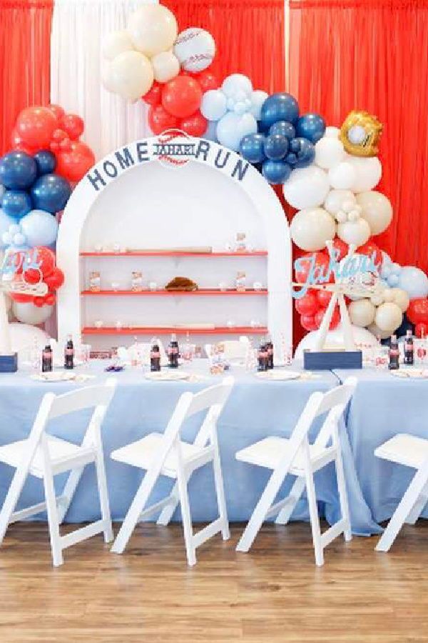 the table is set up for a home run party with balloons and decorations on it