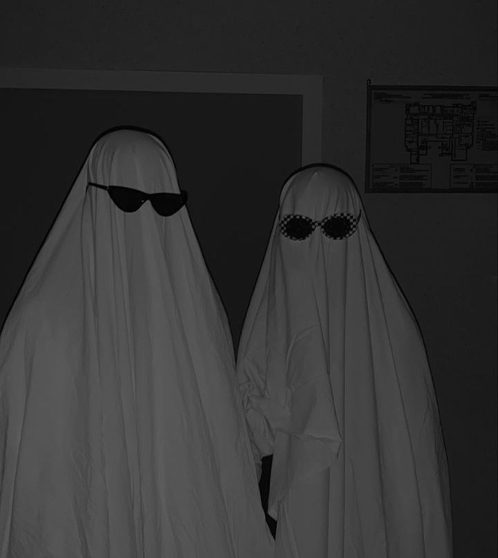 two people dressed in white and black are standing next to each other with sunglasses on their heads