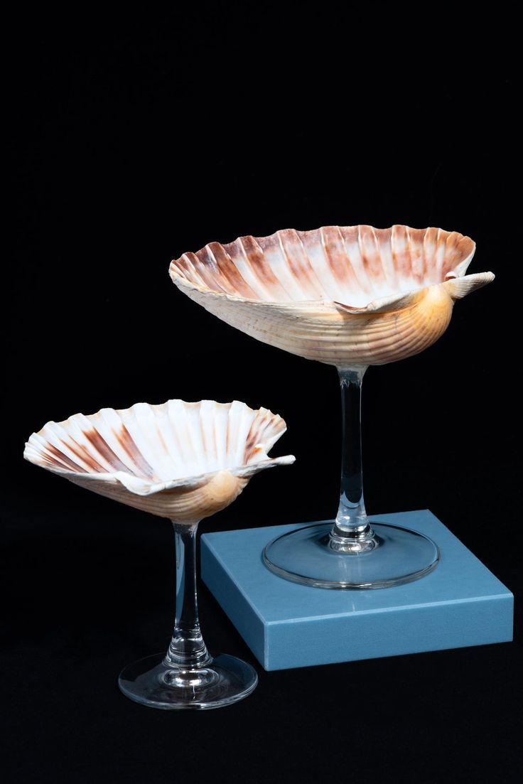 two glass bowls sitting on top of a blue stand