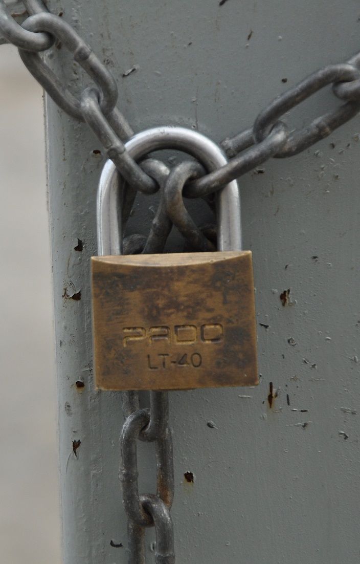 an old padlock attached to a metal pole