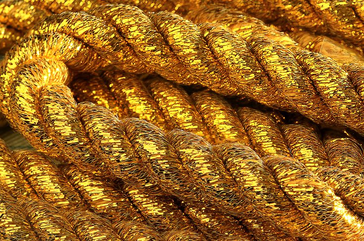 many gold colored ropes stacked on top of each other