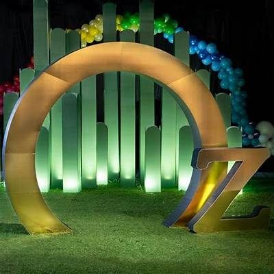 an illuminated arch and bench in front of a fence