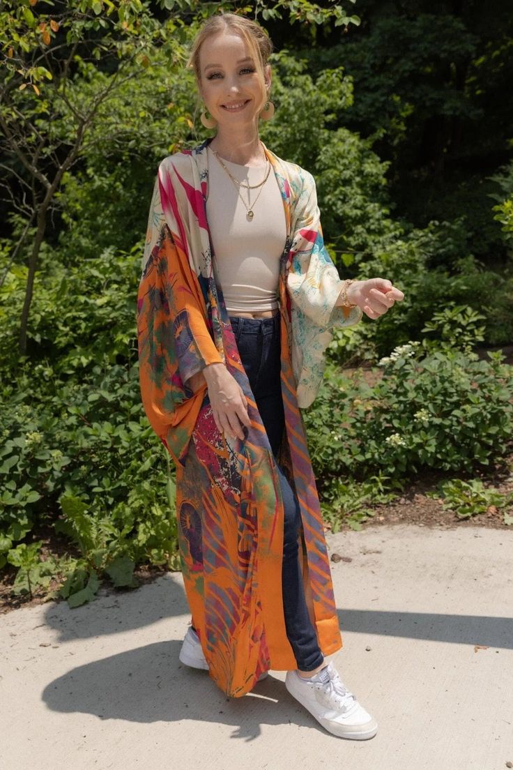 Our Multicolored Abstract Floral Kimono features traditional kimono sleeves with large floral motifs in black with bright blue outlining that drape when worn and displays a large, golden floral motif with abstract polychromatic designs running through it on the backside. The flowy, relaxed fit of the kimono and the lightweight, breathable, and silky feel will easily make this your go-to kimono. Material: Viscose Satin Body Length Hps to Hem: 53 1/2" Sleeve Length: 13" Armhole Straight: 13 1/2" S Kimono With Vibrant Print For Festivals, Festival Kimono With Vibrant Print, Oversized Silk Bohemian Kimono, Multicolor Flowy Long Kimono, Multicolor Long Flowy Kimono, Flowy Multicolor Long Kimono, Silk Kimono For Fall, Spring Kaftan With Kimono Sleeves And Relaxed Fit, Flowy Multicolor Kimono With Kimono Sleeves