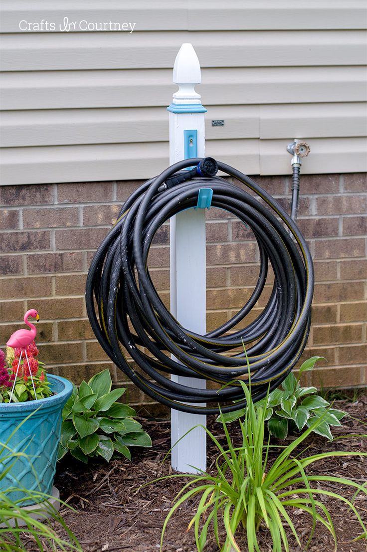 a garden hose is attached to a white pole