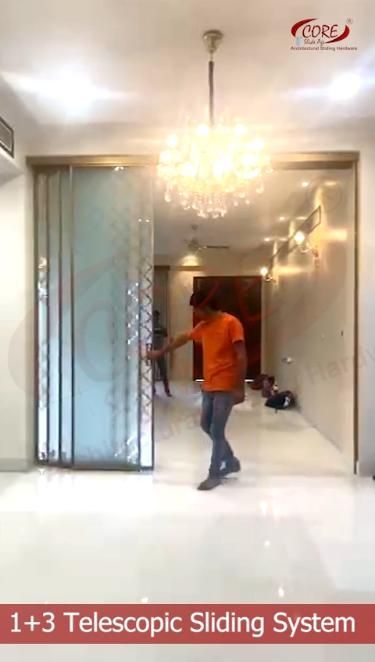 a man in an orange shirt is walking into a room with a chandelier