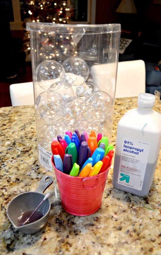 a cup filled with lots of colored markers next to a bottle of lotion and a measuring spoon