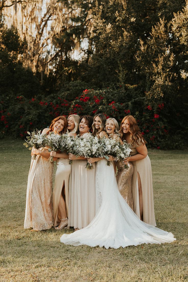 a group of women standing next to each other on top of a lush green field