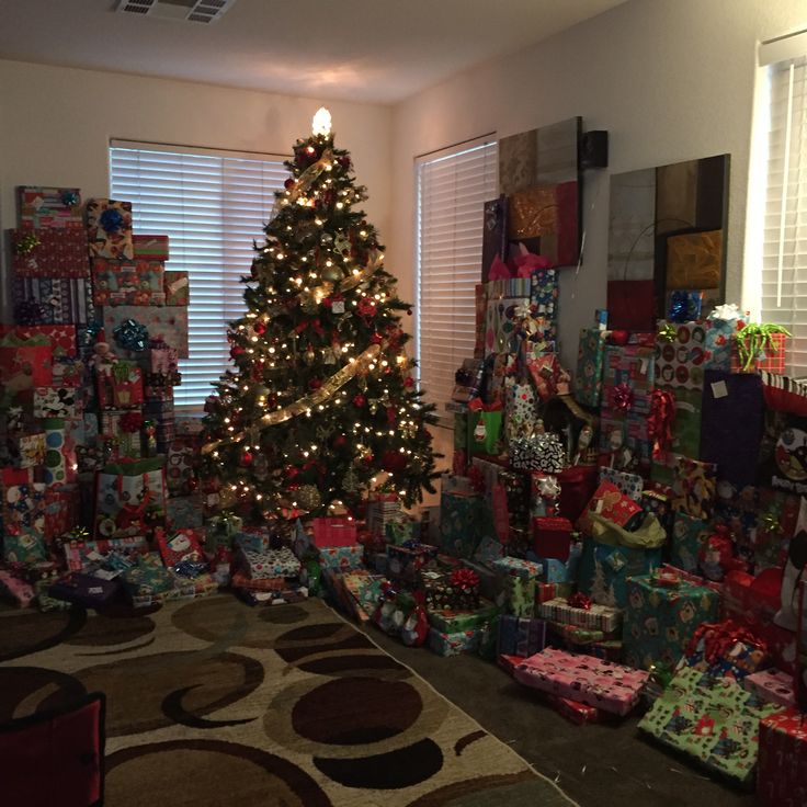 a christmas tree is surrounded by many presents