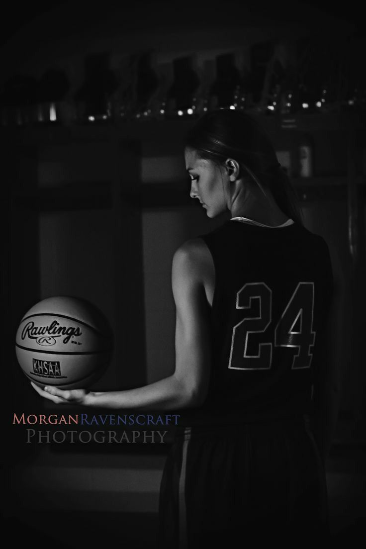 a woman holding a basketball in her hand and wearing a jersey with the number 24 on it