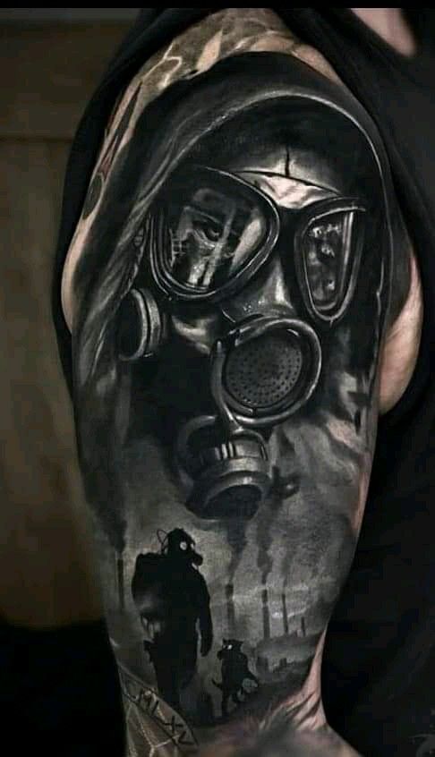 a man with a gas mask tattoo on his arm and shoulder is shown in black and grey