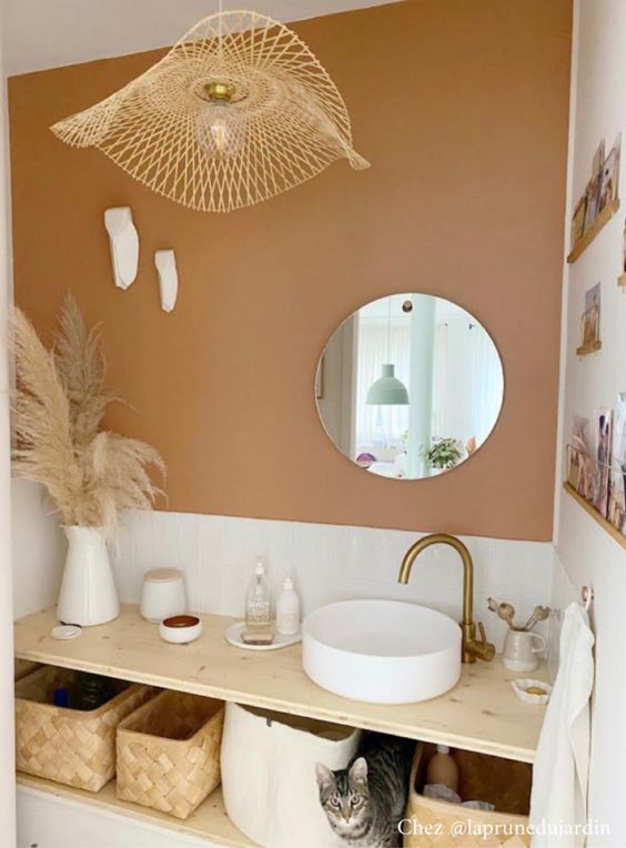 a bathroom with a sink, mirror and hanging lights above the vanity area is decorated in neutral colors