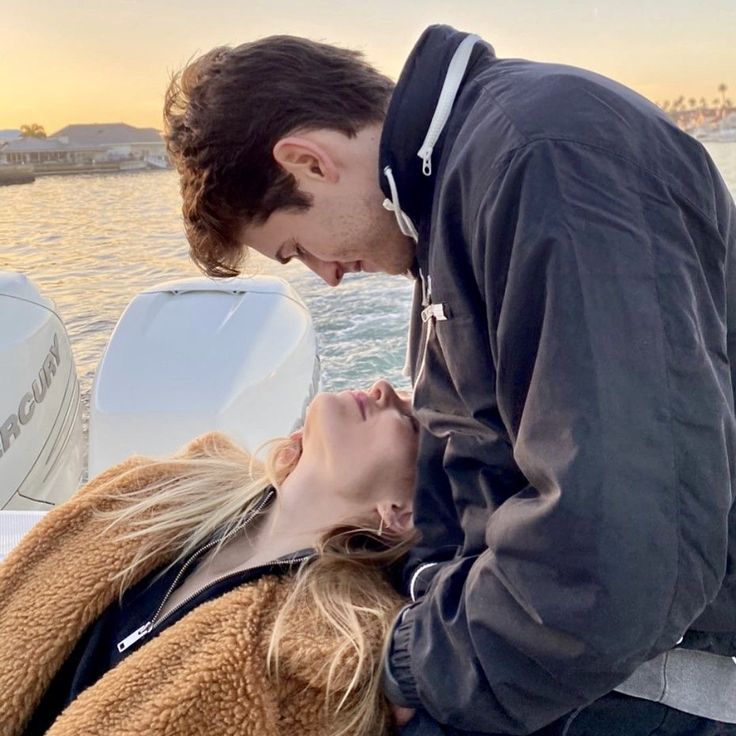 a man kissing a woman on the back of a boat