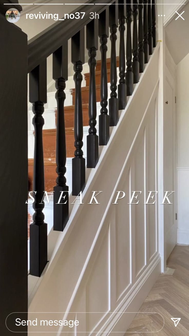 an image of a staircase with black handrails and wood flooring in the background