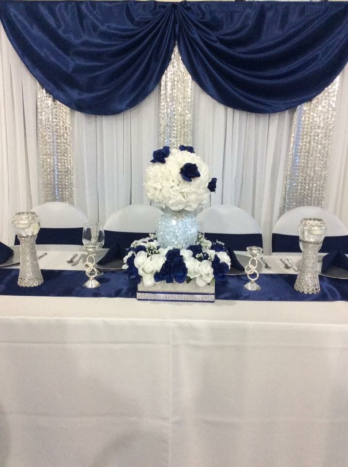 a blue and white table cloth with flowers on it at a wedding reception in front of a window