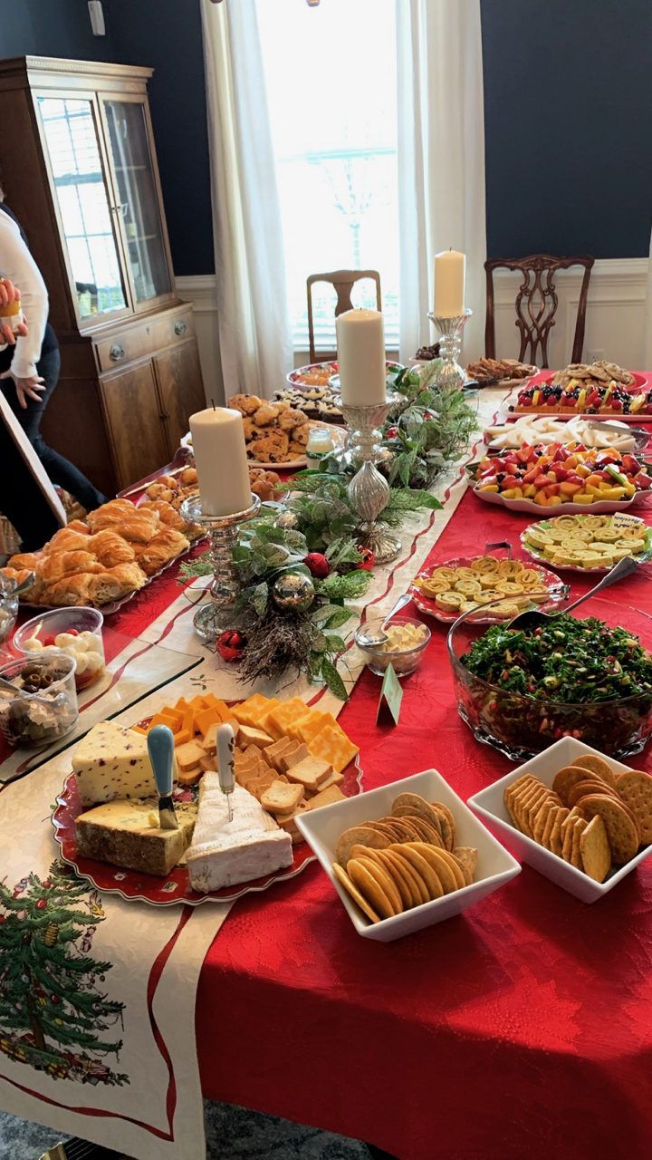 a red table cloth covered with food and plates filled with breads, crackers