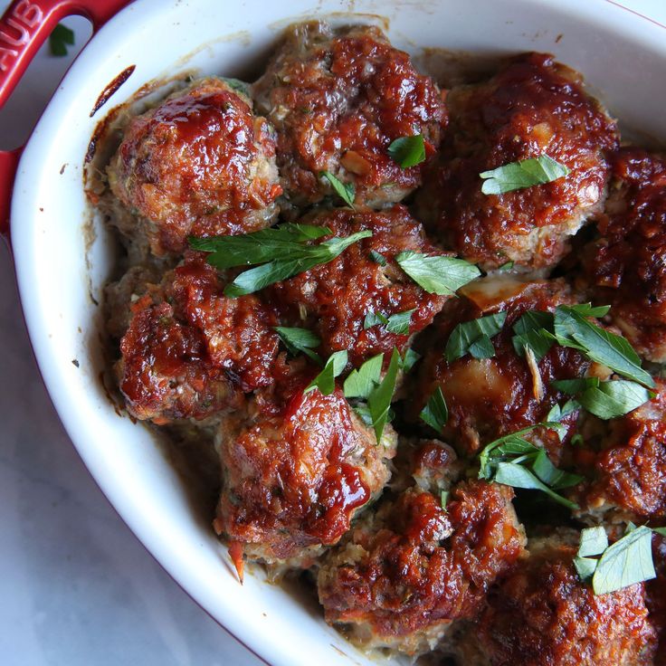 meatballs covered in marinara sauce and garnished with parsley