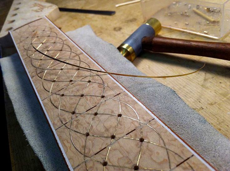 a piece of wood that is being worked on with some wire attached to the edge