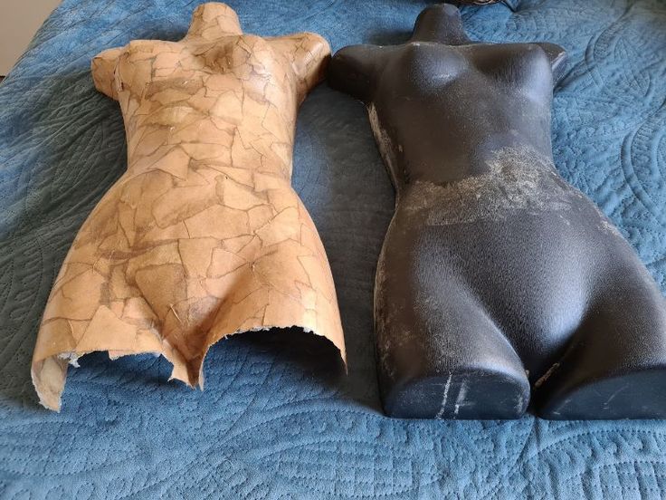 two clay bears laying on top of a bed