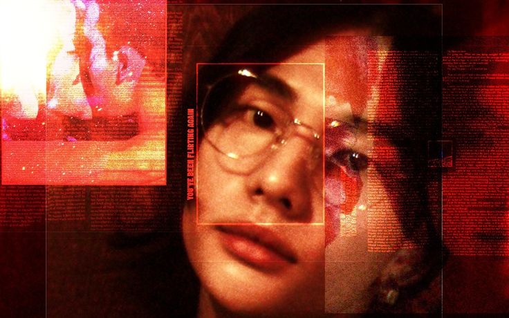 a woman wearing glasses and looking at the camera in front of her is a red background