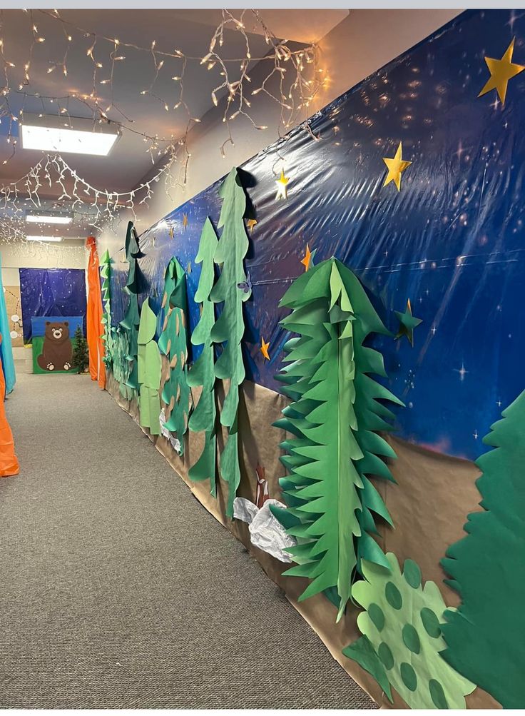 an office decorated for christmas with trees and stars on the wall in front of it