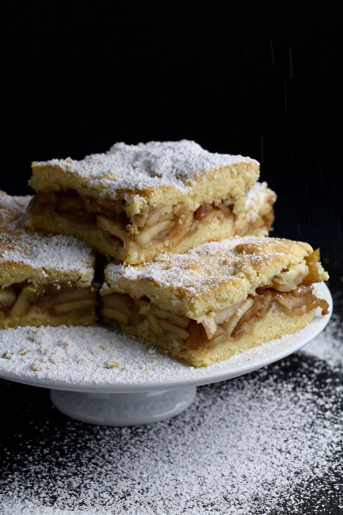 three pieces of apple pie on a plate with powdered sugar