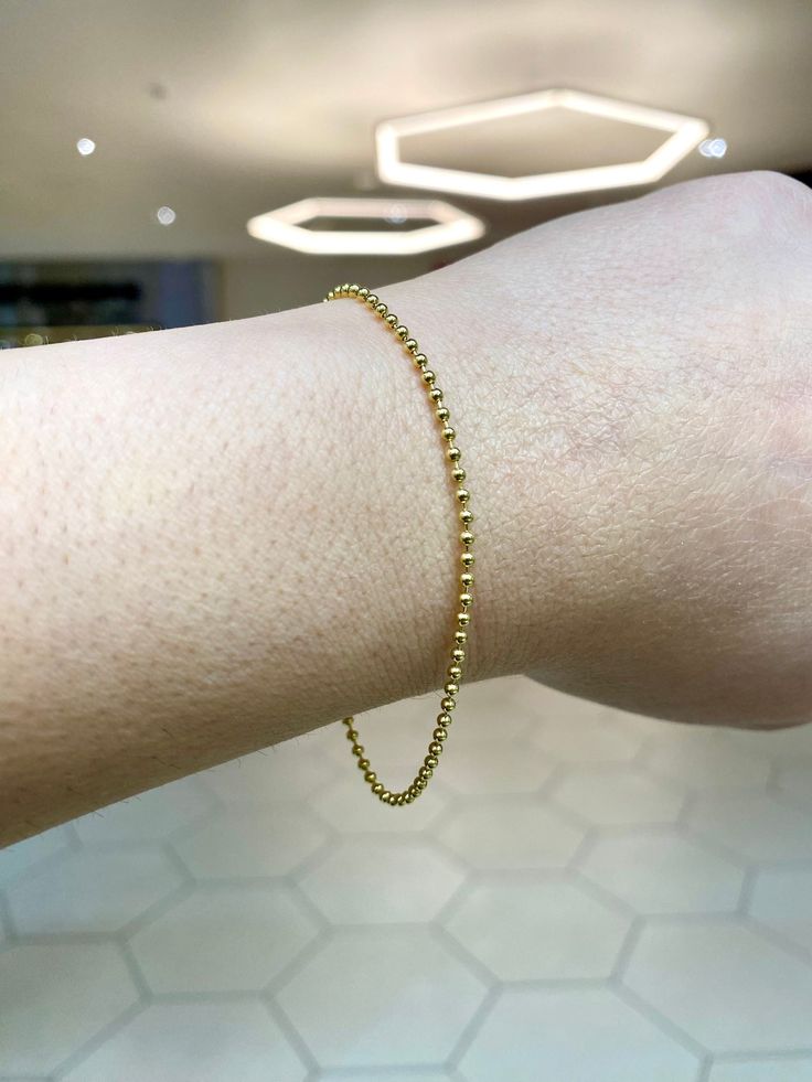 Timeless 14k real gold dainty bead bracelet.  Material: 14k gold. Length: Approximately 7.25 inches. Width: Approximately 1.5mm bead. Weight: Approximately 2 grams. Comes in a nice box. Dainty Yellow Gold Beaded Bracelets In 14k Gold Filled, Dainty 14k Gold Beaded Bracelet With Round Beads, Dainty 14k Gold Bracelets With Round Beads, Elegant Beaded 14k Gold-filled Bracelets, Elegant 14k Gold-filled Beaded Chain Bracelet, Minimalist Yellow Gold Beaded Bracelets, 14k Gold Beaded Bracelets With Tiny Beads, Gold Minimalist Single Strand Beaded Bracelet, Dainty Yellow Gold Bracelet With Beaded Chain