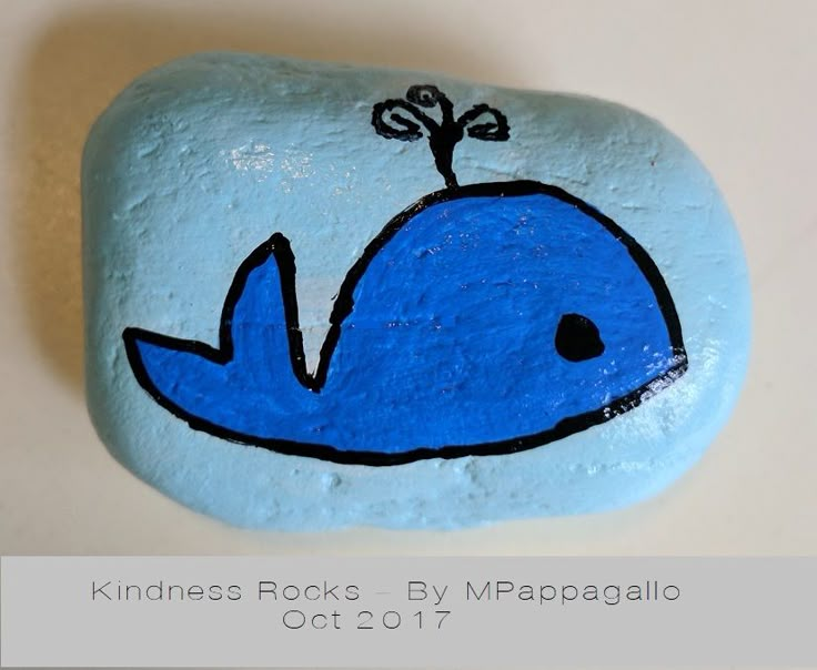 a painted rock with a blue whale on it