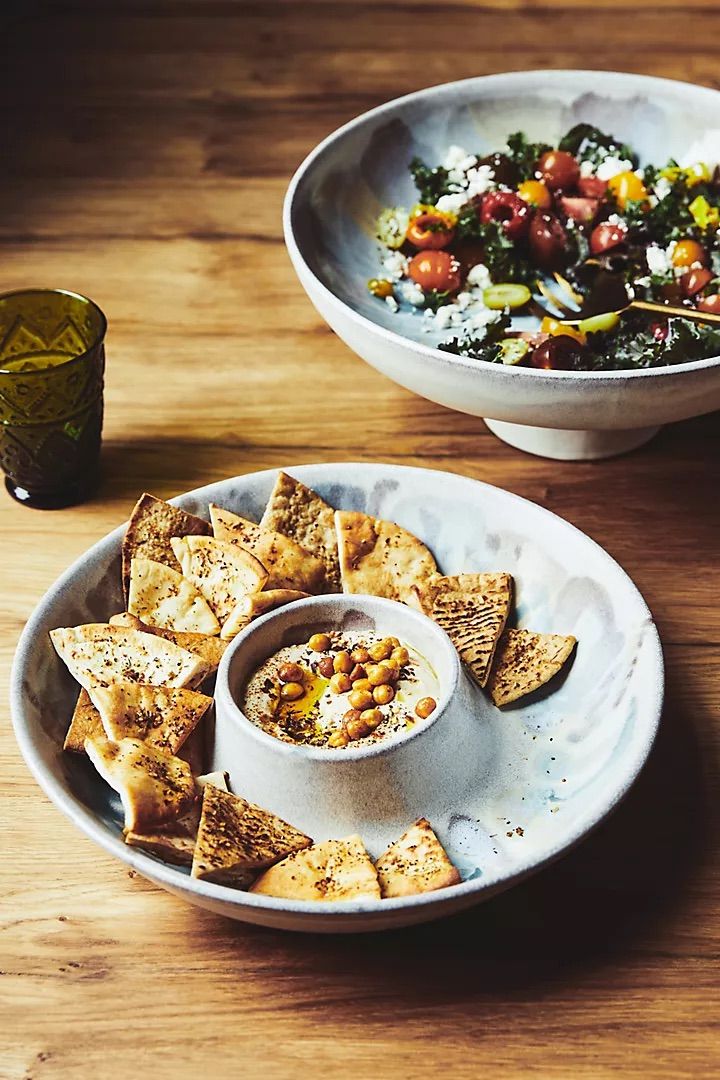 two bowls filled with food on top of a wooden table