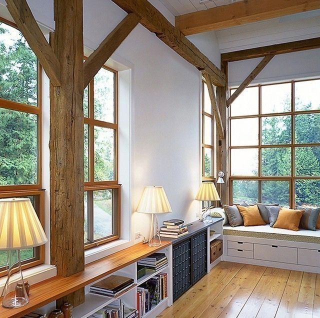 a living room filled with lots of furniture next to large windows covered in wood planks