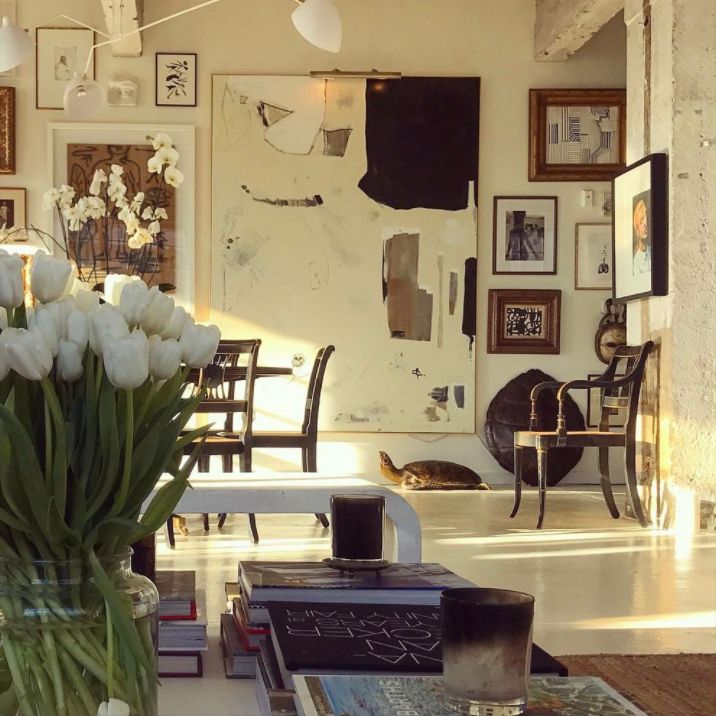 a vase filled with white flowers sitting on top of a table next to a wall