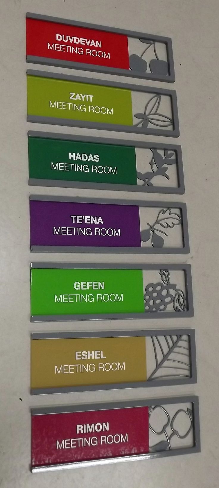 four metal name tags with different colors on them