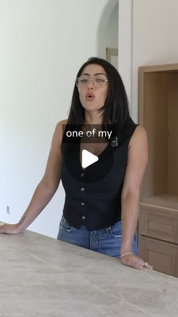 a woman standing in front of a counter with the words one of my on it