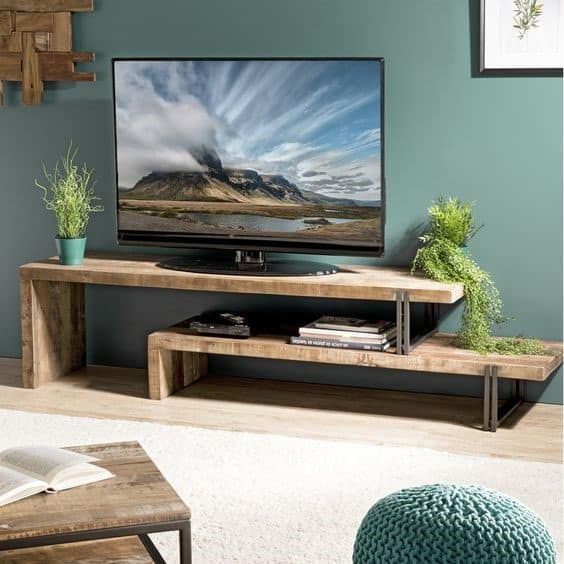 a flat screen tv sitting on top of a wooden stand in front of a green wall