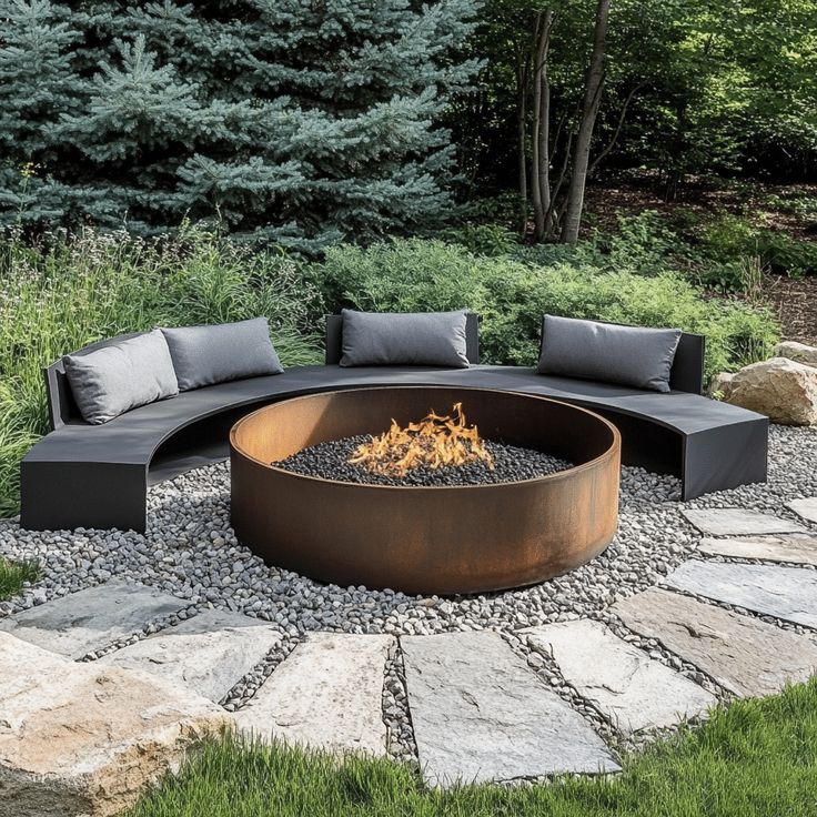 an outdoor fire pit surrounded by rocks and grass