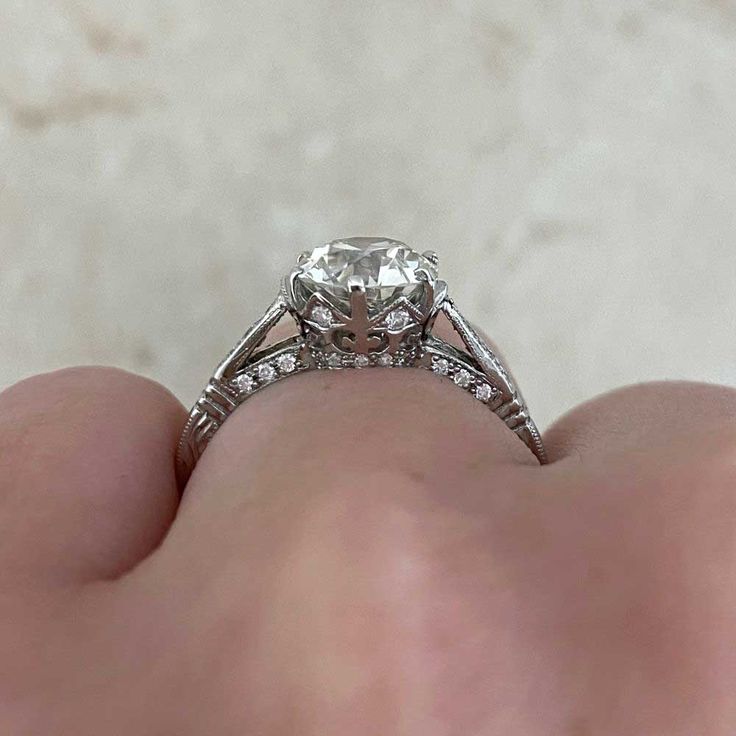 a close up of a person's hand holding an engagement ring