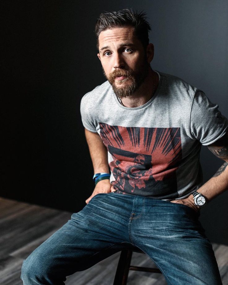 a man sitting on top of a wooden stool