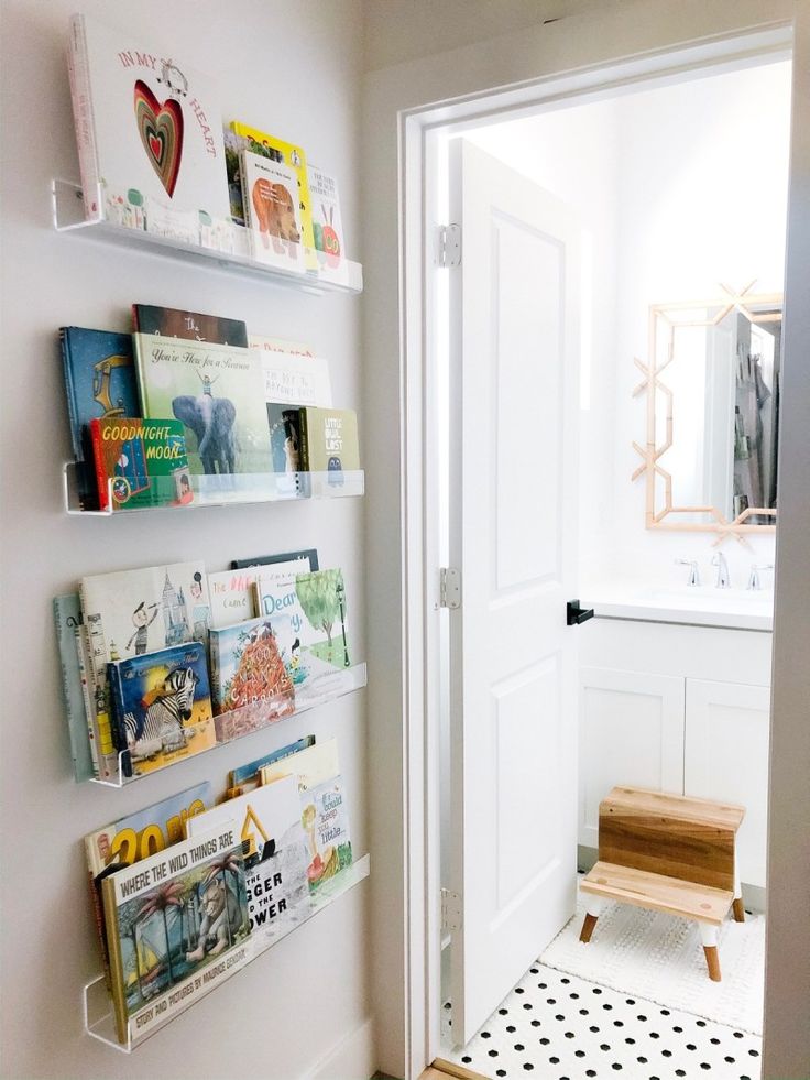 there are books on the shelves in this room, along with a bench and mirror