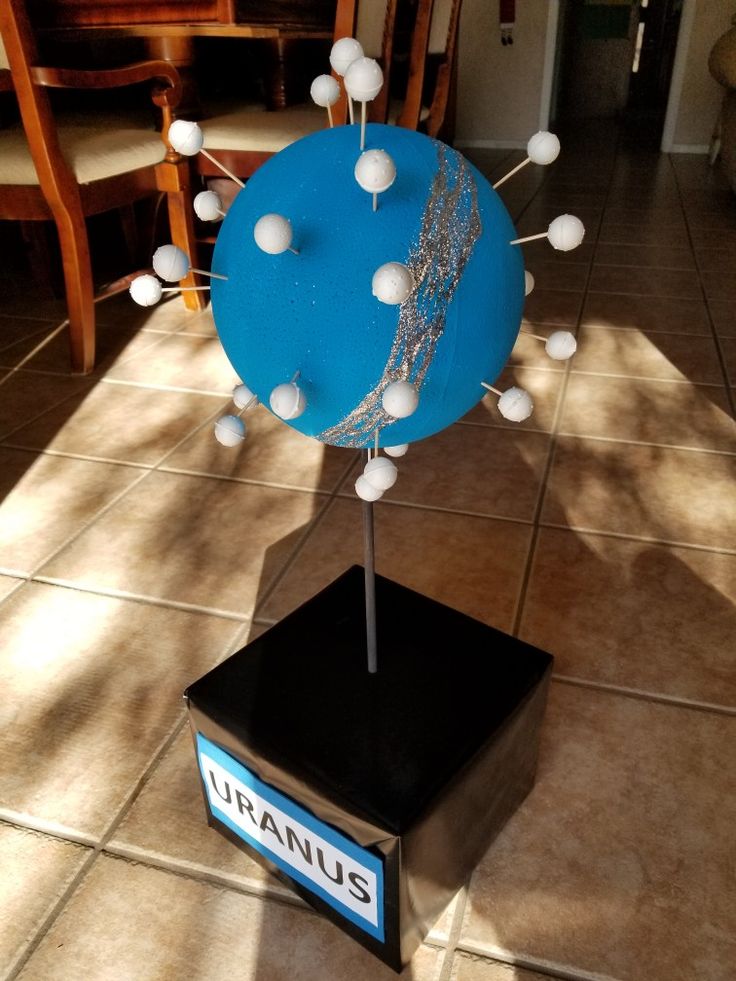 a blue and white sculpture on top of a black box in the middle of a room