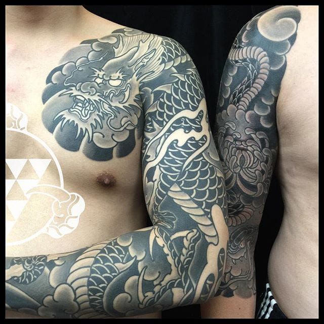 two men with tattoos on their arms and chest