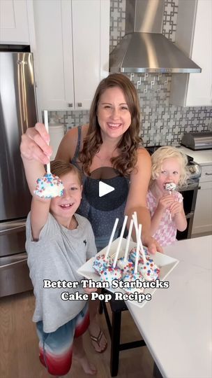 a woman and two children holding up cake pops