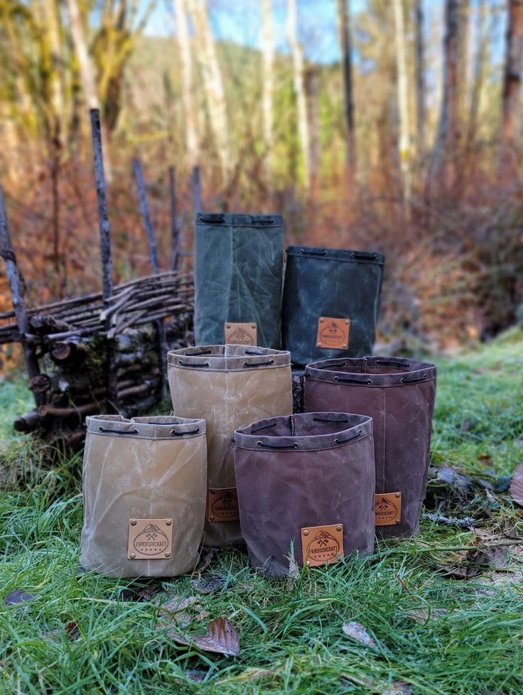 several bags are sitting on the ground in front of some trees and grass with small brown tags